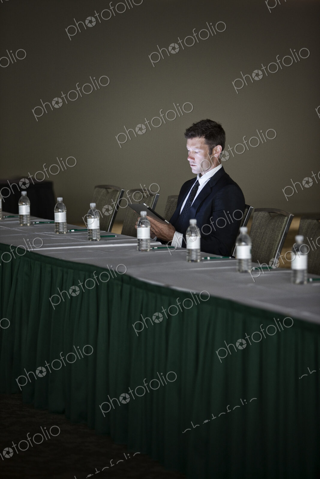 Caucasian businessman sitting alone and using a notebook computer at a convention…