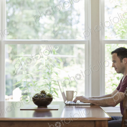 Caucasian businessman working from home using his laptop computer. Caucasian businessman working from home using his laptop computer.
