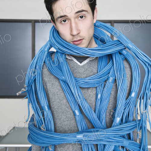 Caucasian businessman wrapped up in CAT 5 copmuter cables from a computer server farm. Caucasian businessman wrapped up in CAT 5 copmuter cables from a computer server farm.