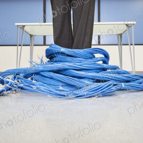 Caucasian businessman wrapped up in CAT 5 copmuter cables from a computer server farm. Caucasian businessman wrapped up in CAT 5 copmuter cables from a computer server farm.