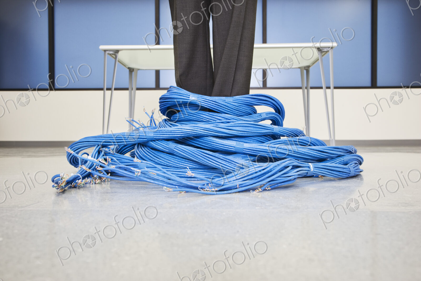 Caucasian businessman wrapped up in CAT 5 copmuter cables from a computer server farm.