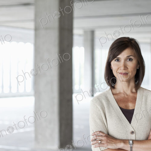 Caucasian businesswoman in a large empty raw office space.