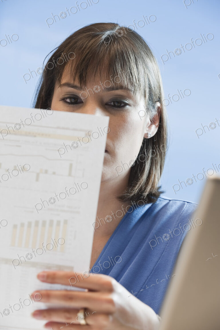 Caucasian businesswoman looking over paperwork.