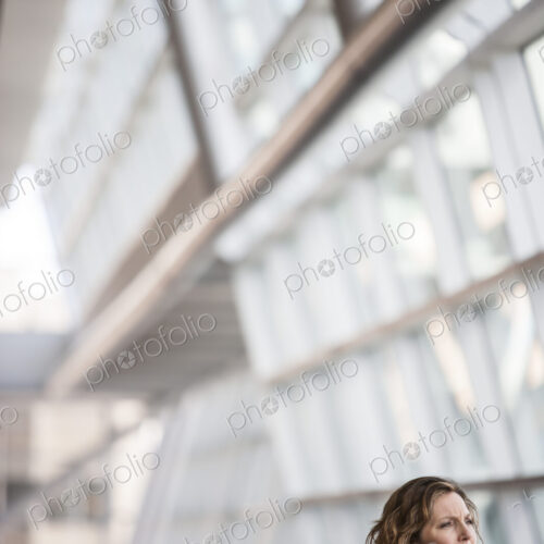 Caucasian businesswoman pausing for a moment near a large window in a conference… Caucasian businesswoman pausing for a moment near a large window in a conference…