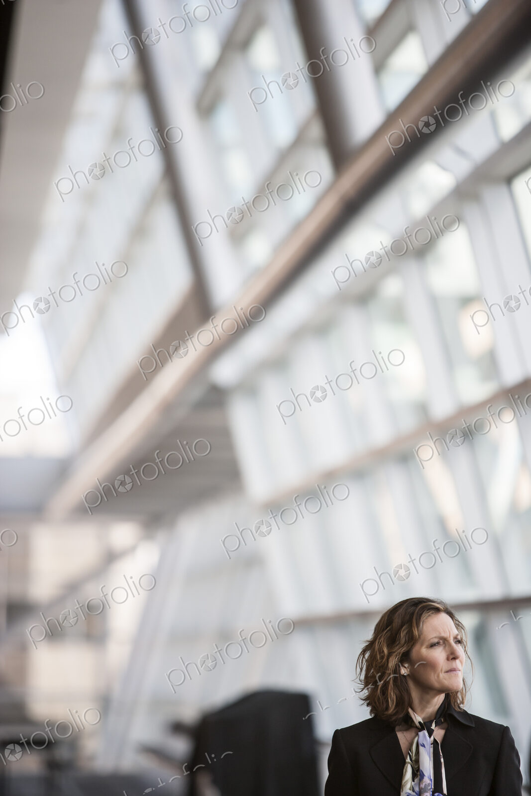 Caucasian businesswoman pausing for a moment near a large window in a conference…