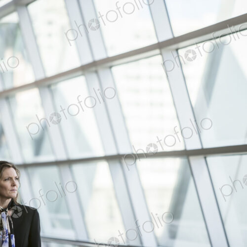 Caucasian businesswoman pausing for a moment near a large window in a conference… Caucasian businesswoman pausing for a moment near a large window in a conference…