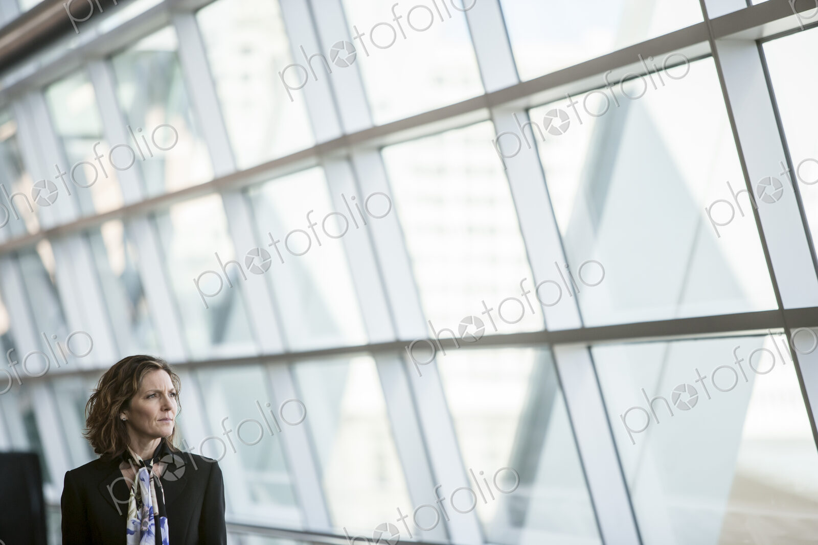 Caucasian businesswoman pausing for a moment near a large window in a conference…