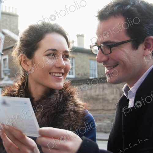 Caucasian couple admiring postcards in gift shop Caucasian couple admiring postcards in gift shop