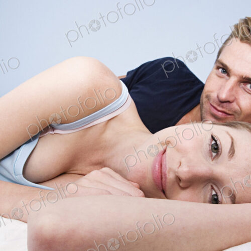 Caucasian couple hugging in bed