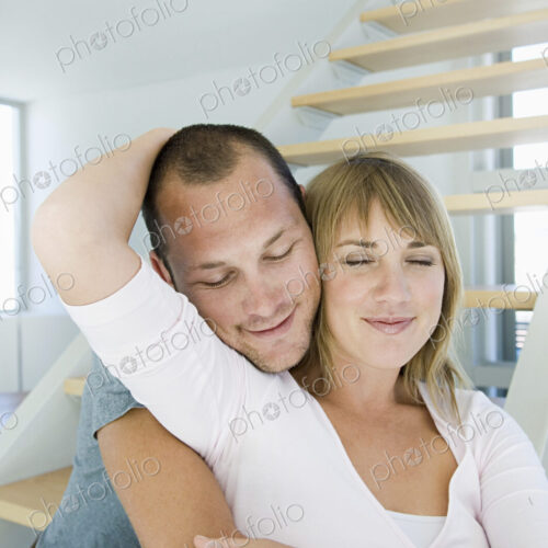 Caucasian couple hugging in modern home
