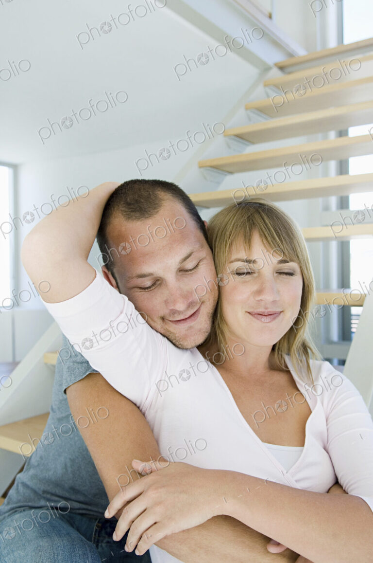 Caucasian couple hugging in modern home