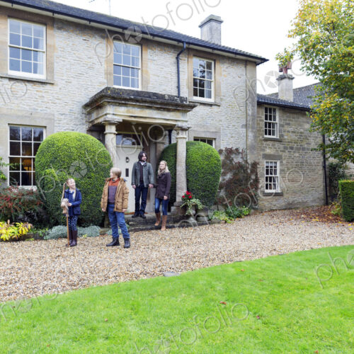 Caucasian family standing near house Caucasian family standing near house