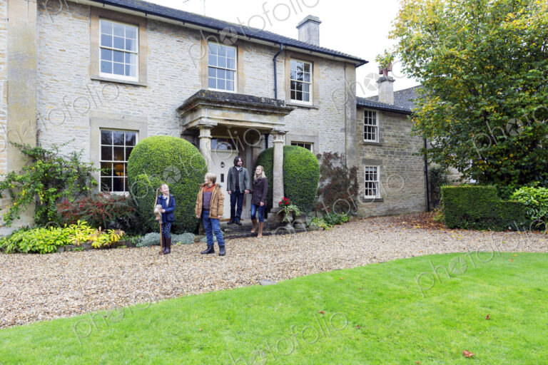 Caucasian family standing near house