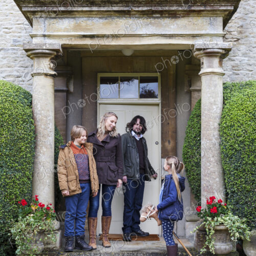 Caucasian family standing on front stoop Caucasian family standing on front stoop