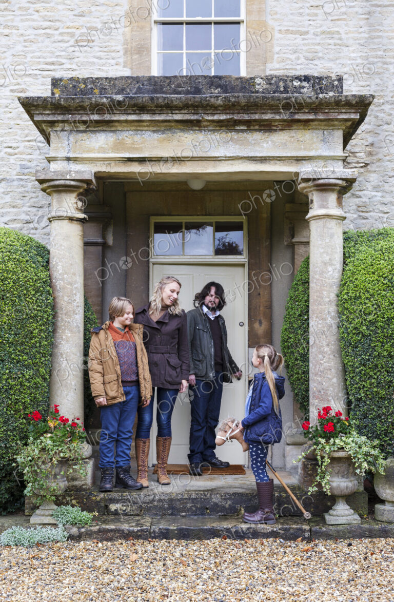 Caucasian family standing on front stoop
