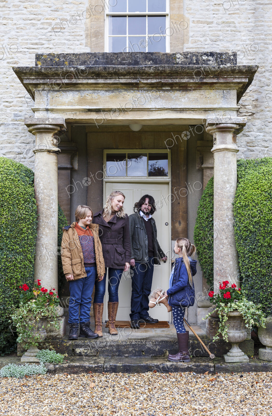 Caucasian family standing on front stoop