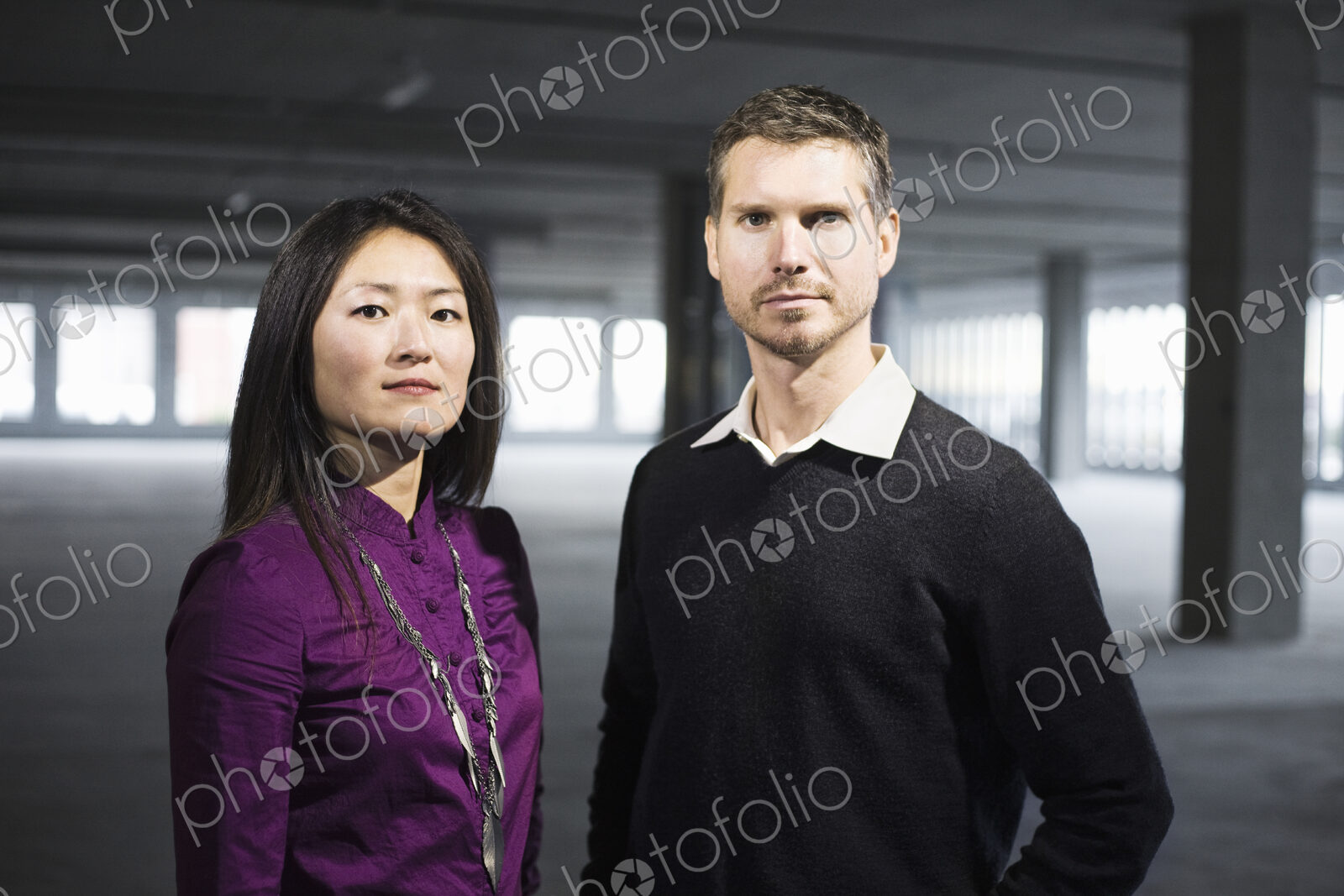 Caucasian male and Asian female business owners in a new raw business space.