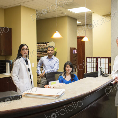 Caucasian male and east Indian woman ophthalmologists in their office with their staff… Caucasian male and east Indian woman ophthalmologists in their office with their staff…