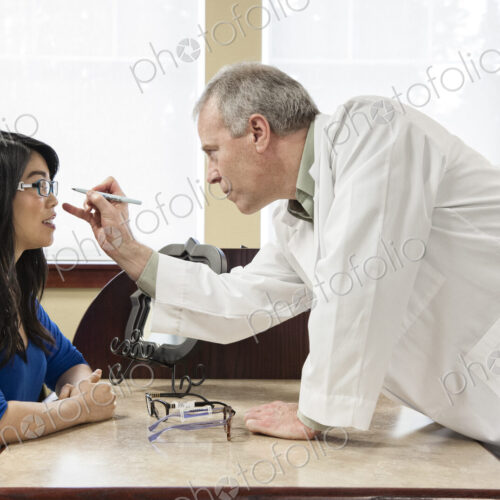 Caucasian male ophthalmologist working with an asian woman who is purchasing a new… Caucasian male ophthalmologist working with an asian woman who is purchasing a new…