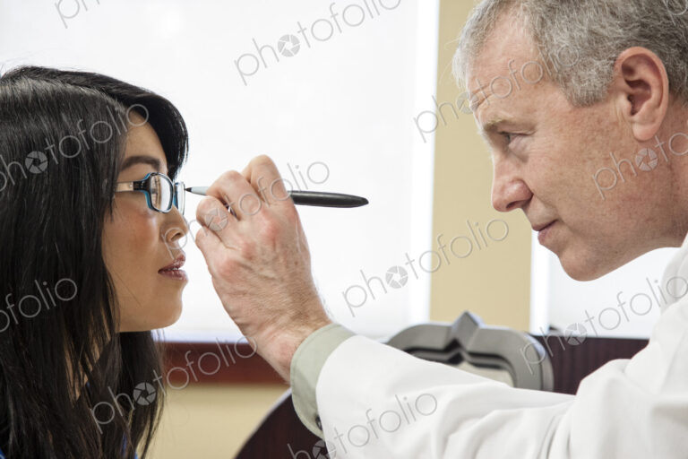 Caucasian male ophthalmologist working with an asian woman who is purchasing a new…