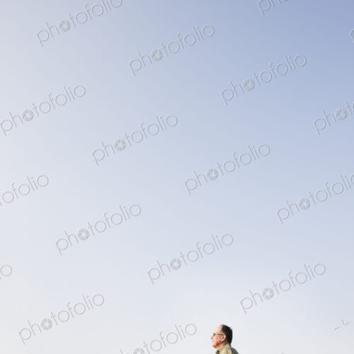 Caucasian male relaxing on the hood of his convertible sports car.