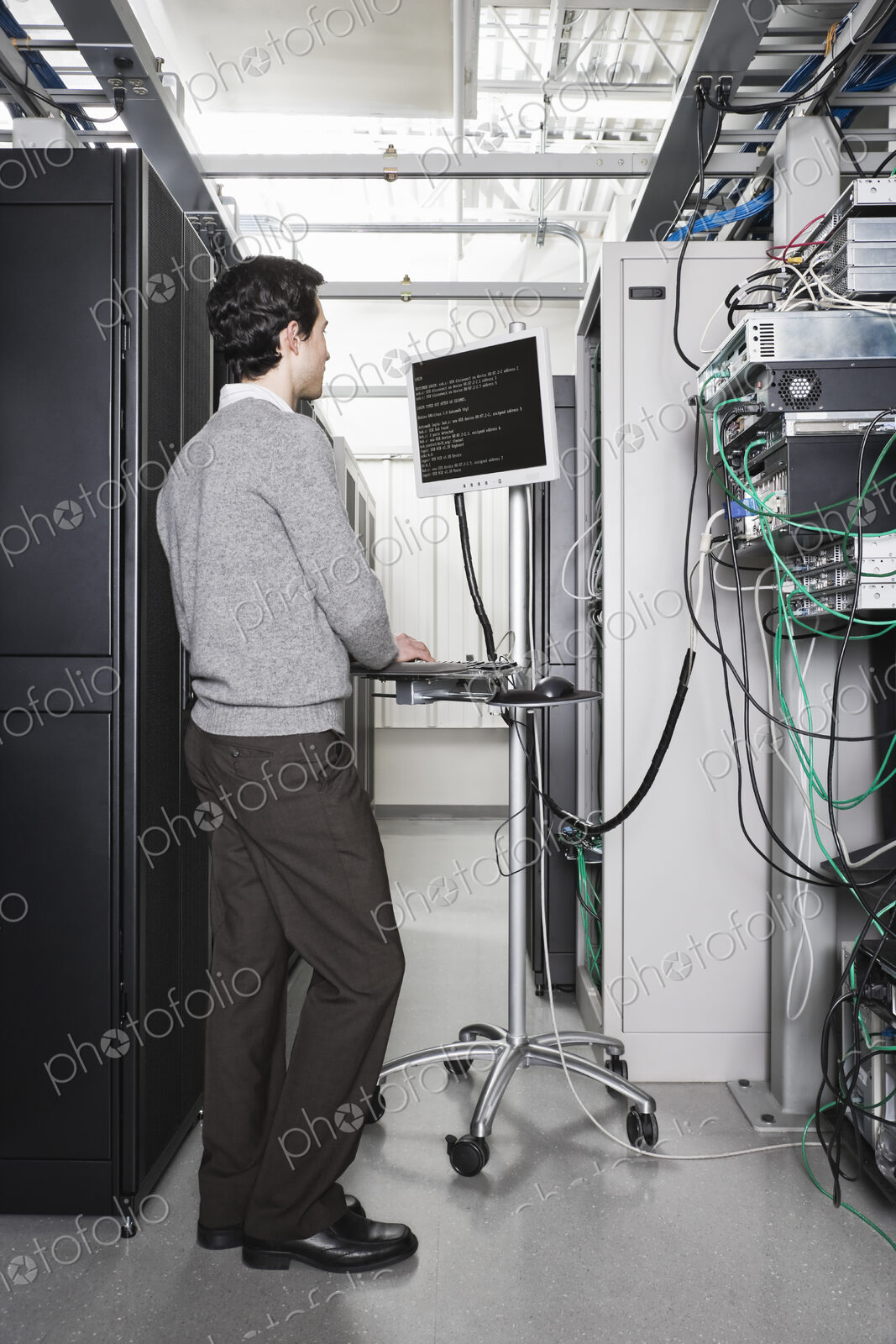 Caucasian male technician working on computer servers in a computer server farm.