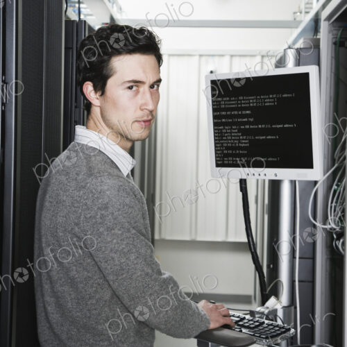 Caucasian male technician working on computer servers in a computer server farm. Caucasian male technician working on computer servers in a computer server farm.