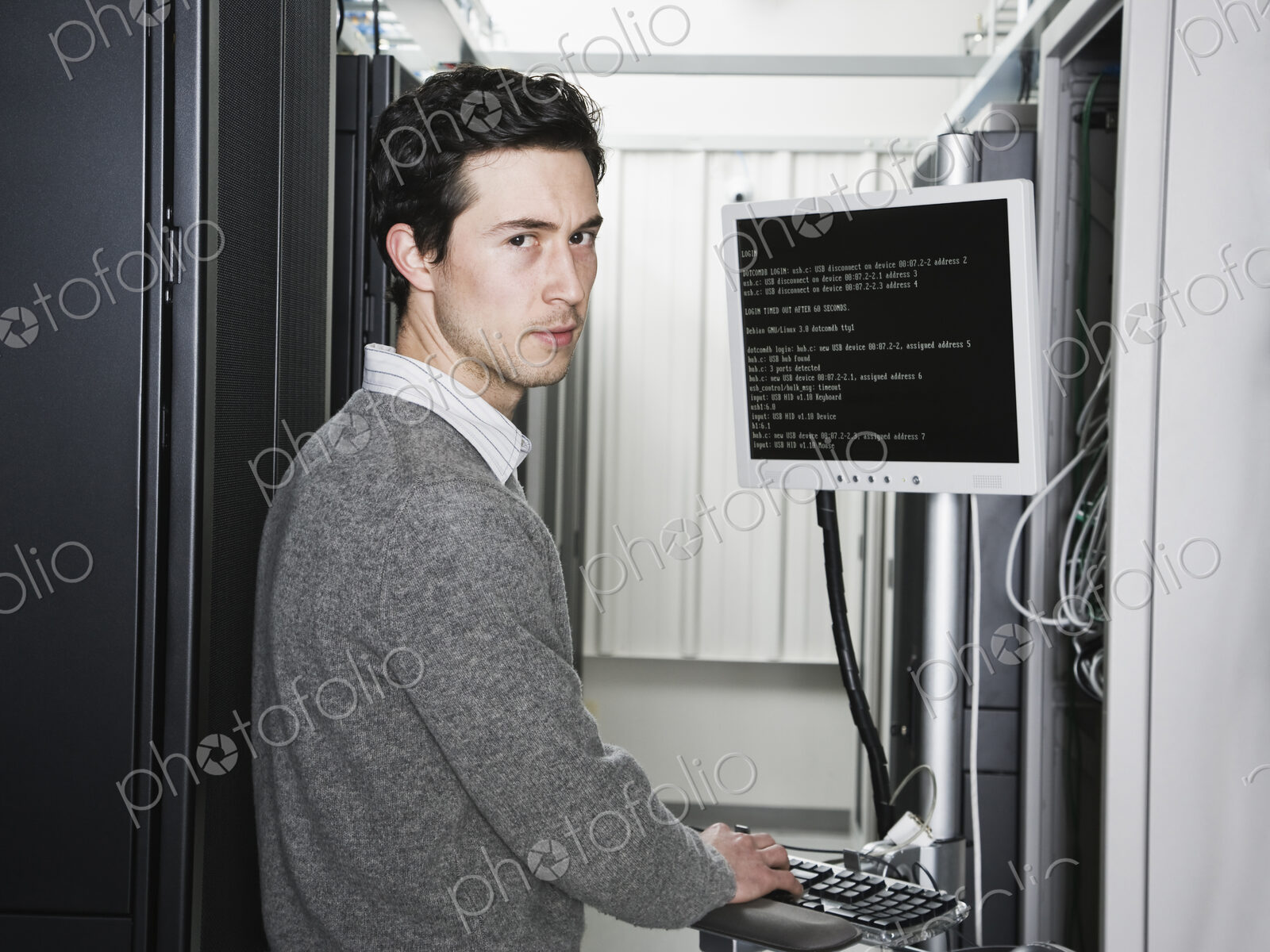 Caucasian male technician working on computer servers in a computer server farm.