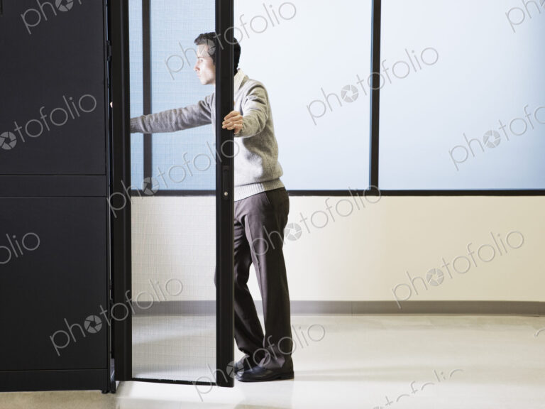 Caucasian male technician working on computer servers in a computer server farm.