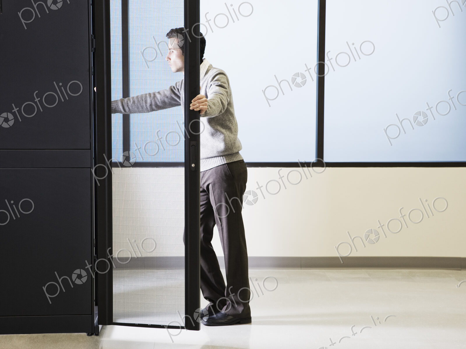 Caucasian male technician working on computer servers in a computer server farm.