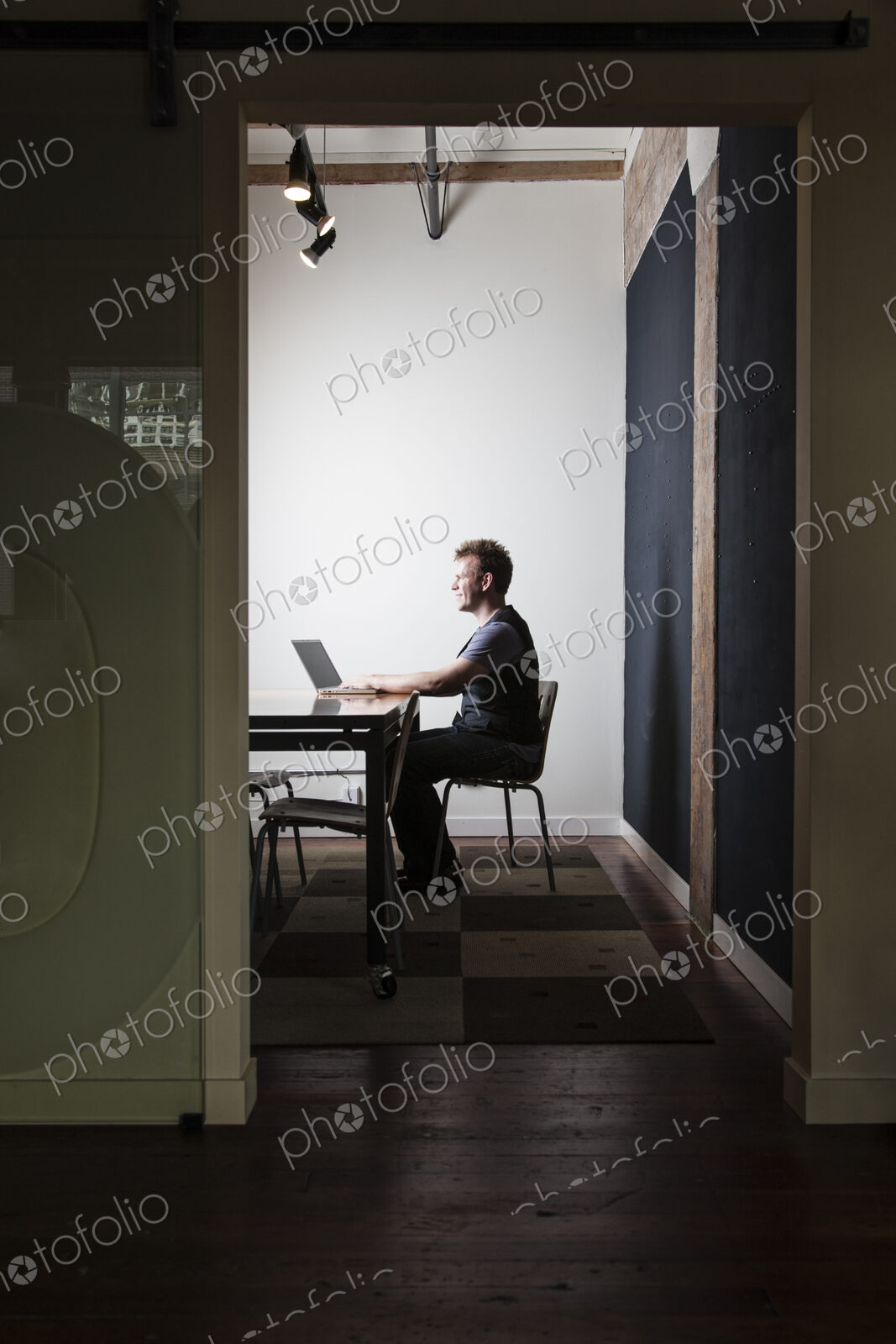 Caucasian male worker using a laptop computere at a conference room table