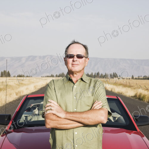 Caucasian man and his car parked on a highway