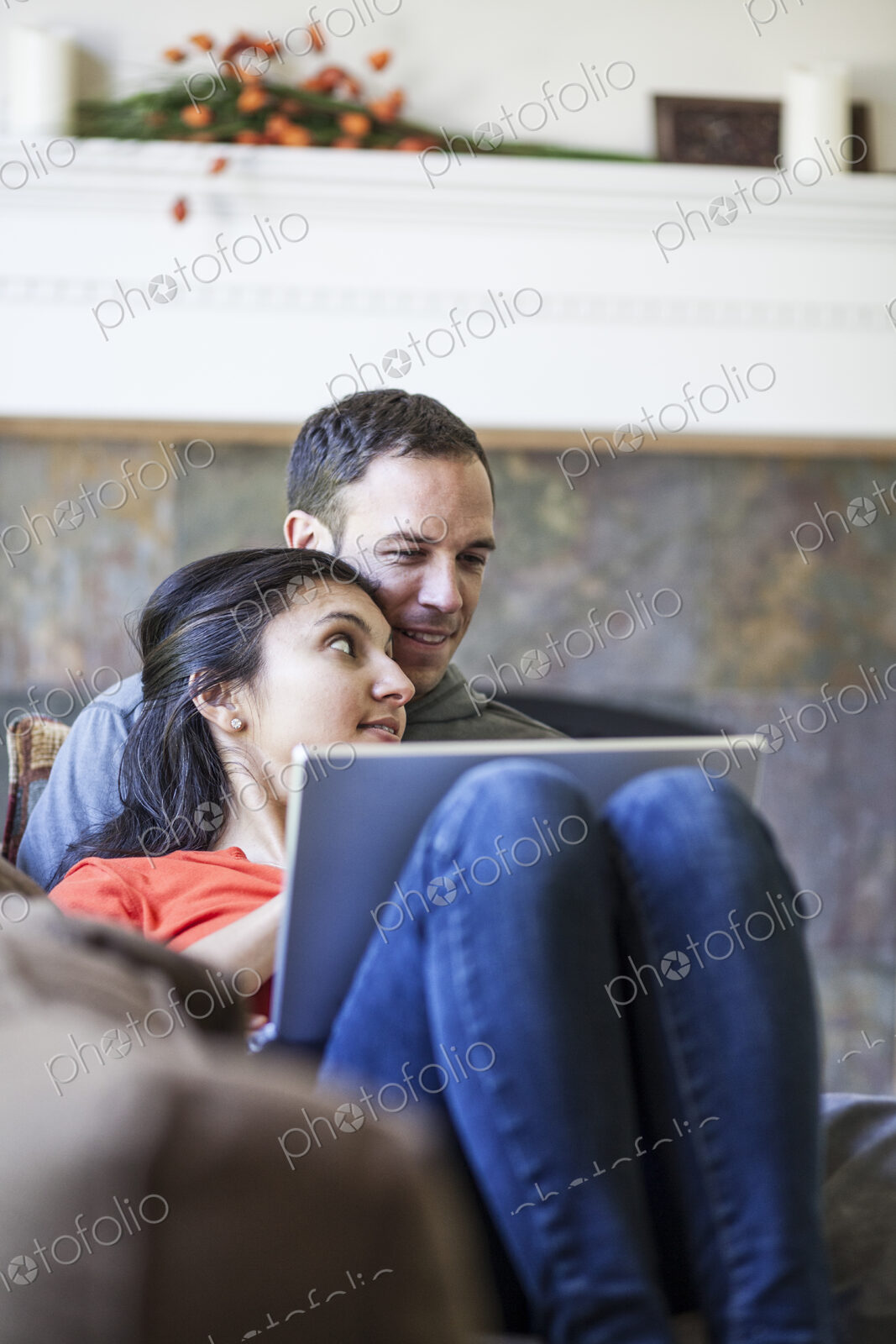 Caucasian man and mixed race caucasian woman using a lap top computer while sitting on…