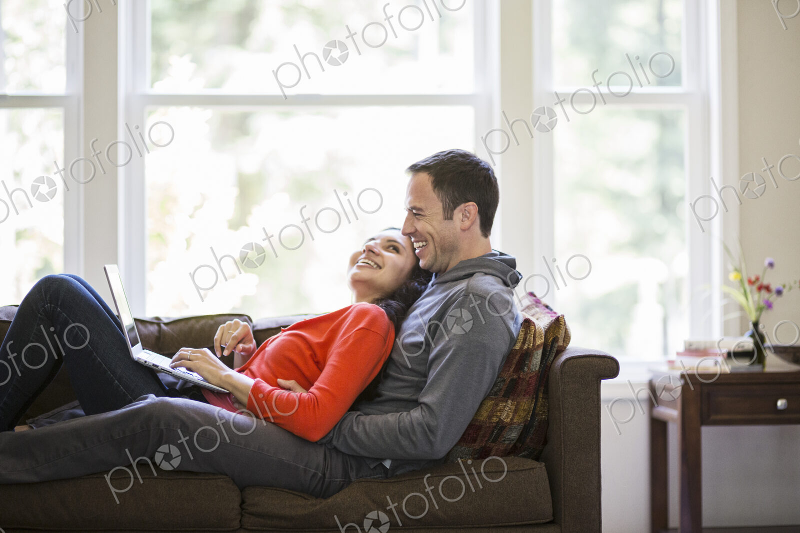 Caucasian man and mixed race caucasian woman using a laptop computer while sitting on…