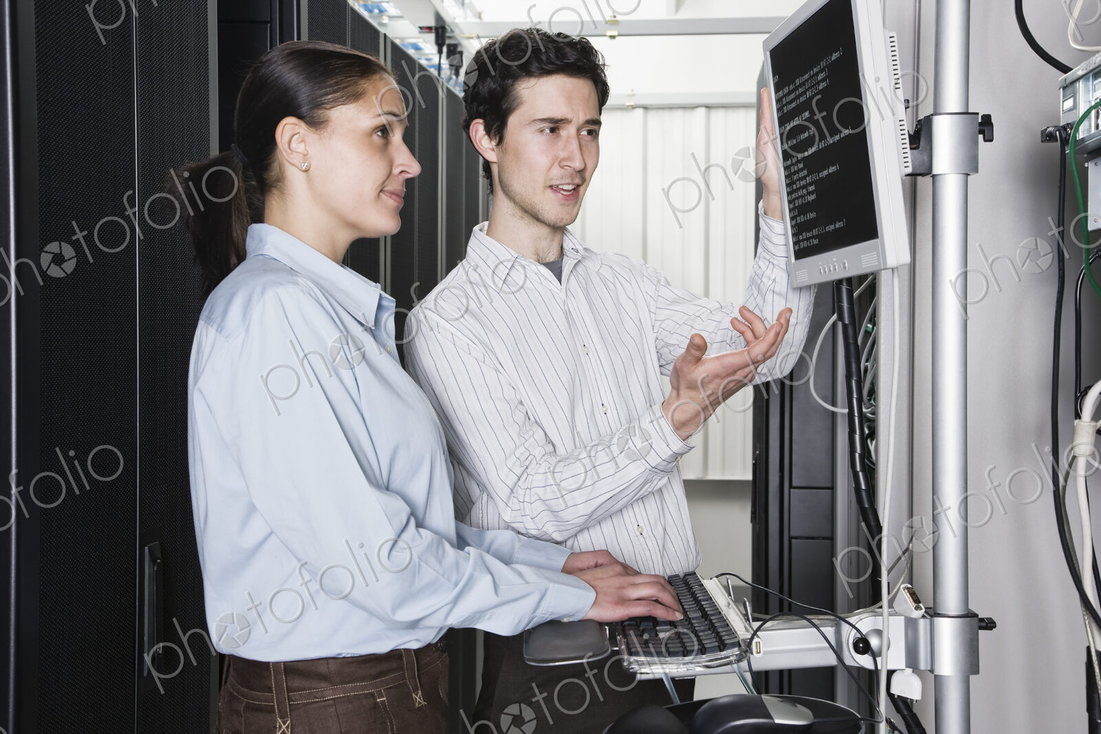 Caucasian man and woman computer technicians checking data on computer servers in a…