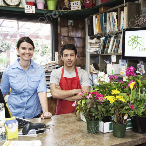 Caucasian man and woman employees of a garden center nursery. Caucasian man and woman employees of a garden center nursery.