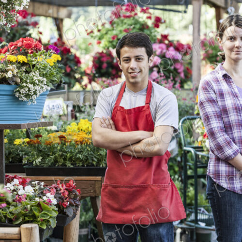 Caucasian man and woman employees of a garden center nursery. Caucasian man and woman employees of a garden center nursery.