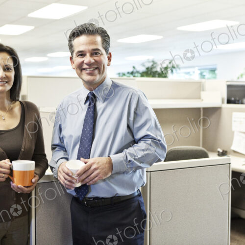 Caucasian man and woman executives in cubicle area of new office space