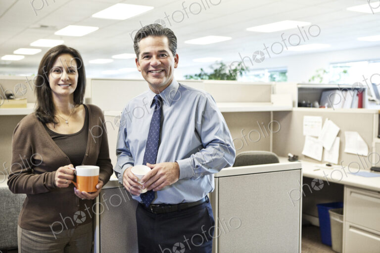 Caucasian man and woman executives in cubicle area of new office space