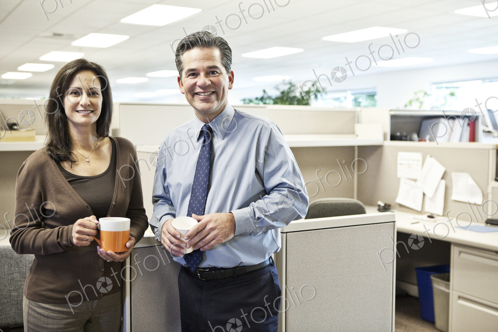 Caucasian man and woman executives in cubicle area of new office space