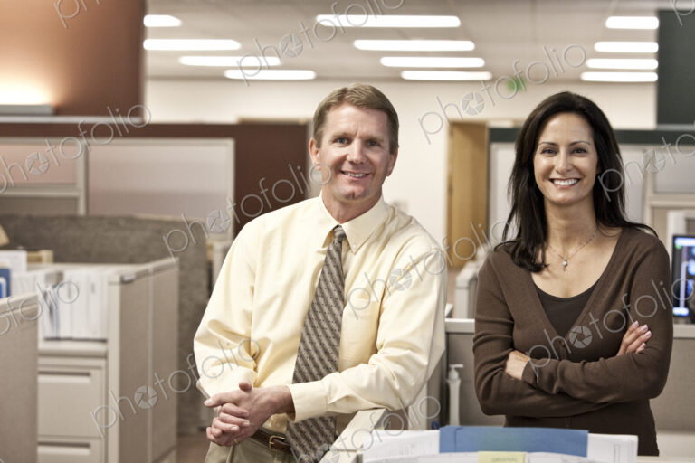 Caucasian man and woman executives in cubicle area of new office space