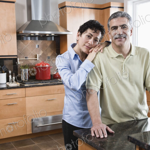 Caucasian man and woman preparing a meal in their new kitchen. Caucasian man and woman preparing a meal in their new kitchen.