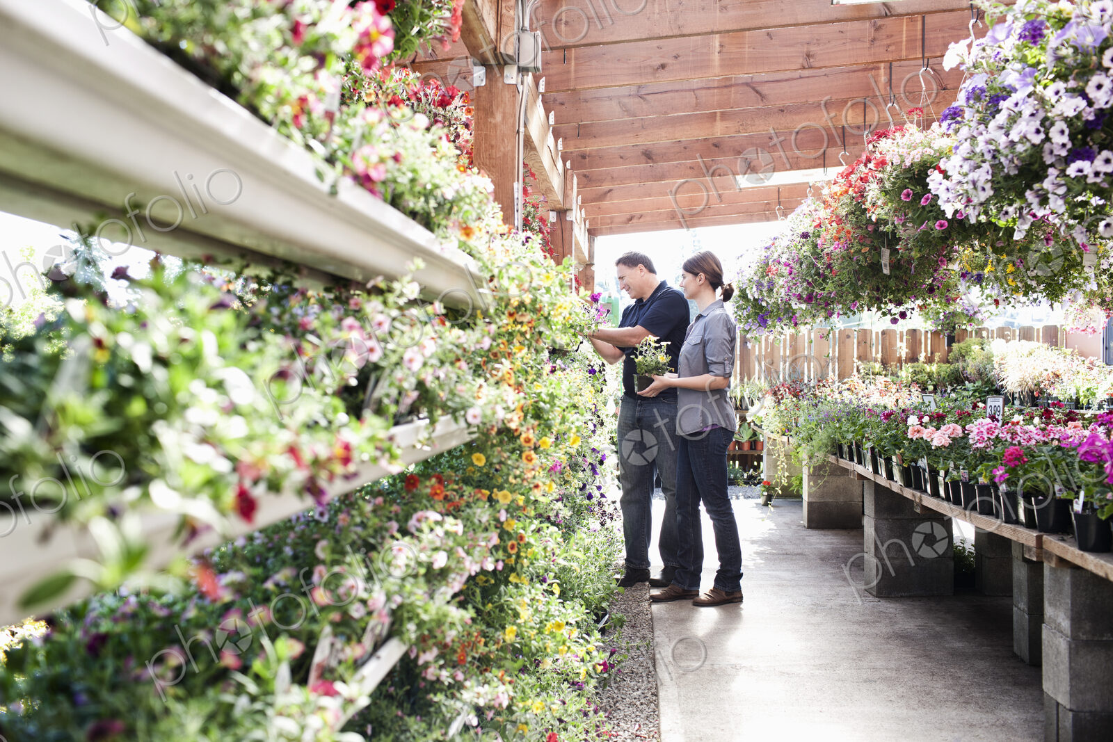 Caucasian man and woman shopping for new plants at a garden center nurery.