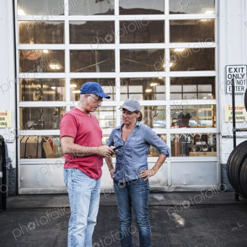 Caucasian man and woman truck drivers in front of an entrance bay at a truck stop… Caucasian man and woman truck drivers in front of an entrance bay at a truck stop…