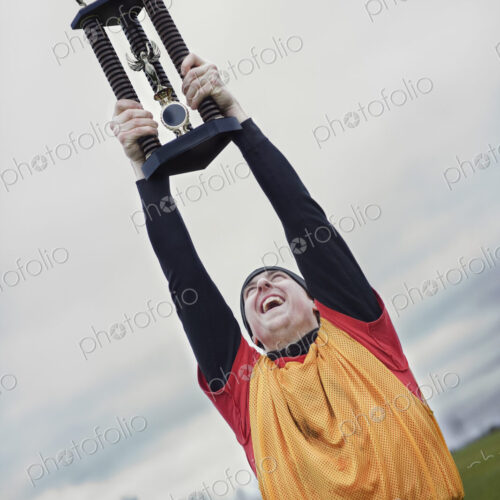 Caucasian man celebrating a sporting event win with a trophy.