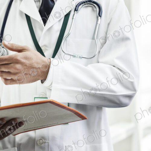 Caucasian man doctor going over a patient history. Caucasian man doctor going over a patient history.