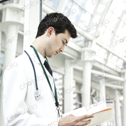 Caucasian man doctor going over a patient history.
