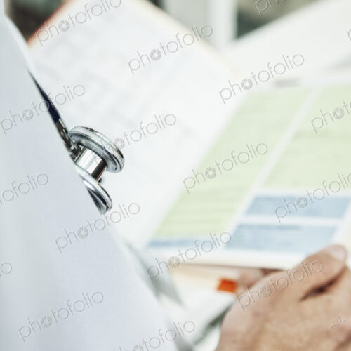 Caucasian man doctor going over a patient history.