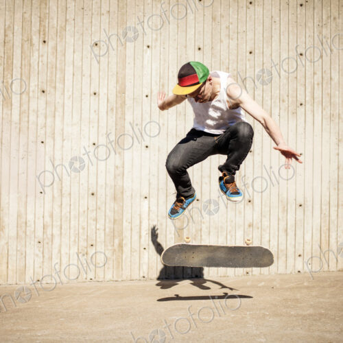 Caucasian man doing skate trick near wooden wall