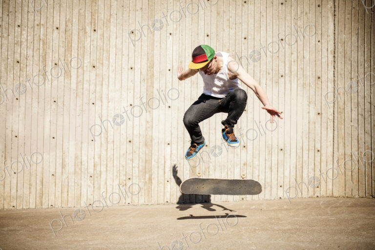 Caucasian man doing skate trick near wooden wall